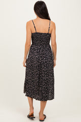 woman wearing a black floral midi dress with adjustable spaghetti straps and a smocked back