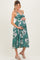 woman wearing a green floral maternity dress with a V-neckline and holding her baby bump