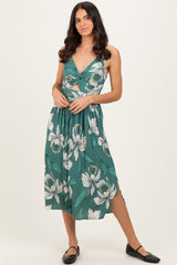 woman wearing a green floral midi dress with a twist front and side slits