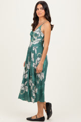 woman wearing a green floral midi dress with a fitted bodice and flowy skirt, styled with black flats