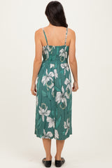 woman wearing a teal floral midi dress with spaghetti straps and a relaxed fit, showing the back view