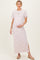 woman wearing a white and pink striped maternity maxi dress and holding her baby bump