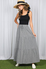 woman wearing a black tank top and a gray striped maxi skirt with tiers and a drawstring waist