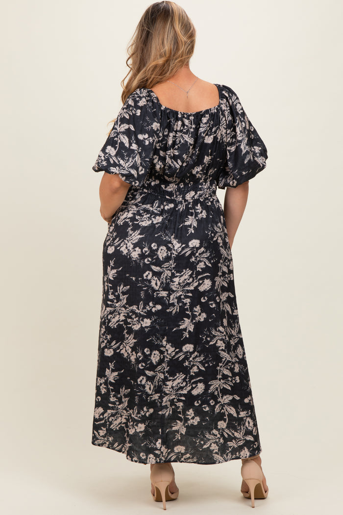 woman wearing a dark floral maternity maxi dress with puff sleeves, showing her back and long skirt