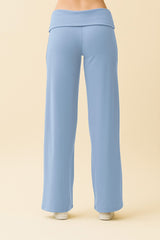 woman wearing light blue wide-leg lounge pants with a foldover waistband from the back