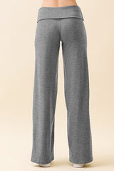 woman wearing gray wide leg lounge pants with a fold-over waistband, shown from the back