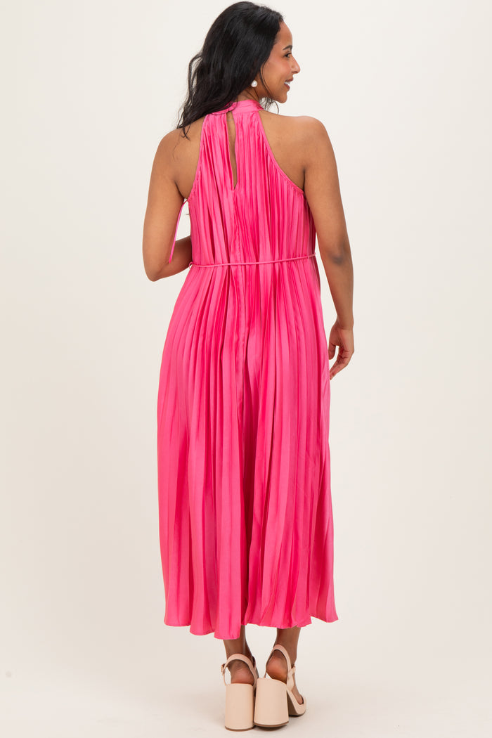 woman wearing a bright pink maternity pleated maxi dress, showing a keyhole back detail