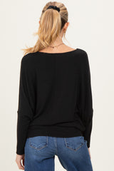 woman wearing a black maternity sweater, styled with a relaxed fit, showing the back view