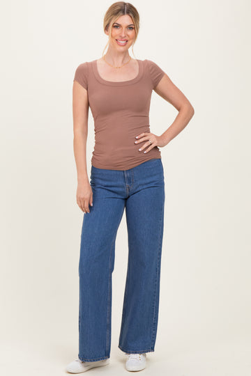 woman wearing a brown ribbed scoop neck fitted top and wide-leg blue jeans