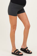 woman wearing dark gray maternity shorts with a stretchy waistband and showing her baby bump