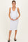 woman wearing a white sleeveless maternity dress and holding her baby bump