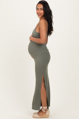 woman wearing a sage green ribbed maternity dress with side slits, showing her baby bump
