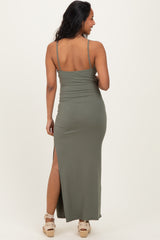 woman wearing an olive green maternity maxi dress with a slit, showing a side view of her figure.