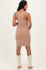 woman wearing a beige ribbed maternity dress with a fitted silhouette and spinning to show the back view