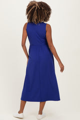 woman wearing a blue sleeveless maternity dress with a gathered waist and a midi length, seen from the back