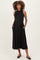 woman wearing a black ribbed maternity dress with a high neckline and pockets, showing her baby bump