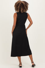 woman wearing a black sleeveless midi maternity dress, showing the back view