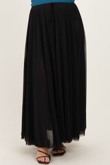 woman wearing a black flowy maternity maxi skirt with a drawstring waist and sheer overlay.