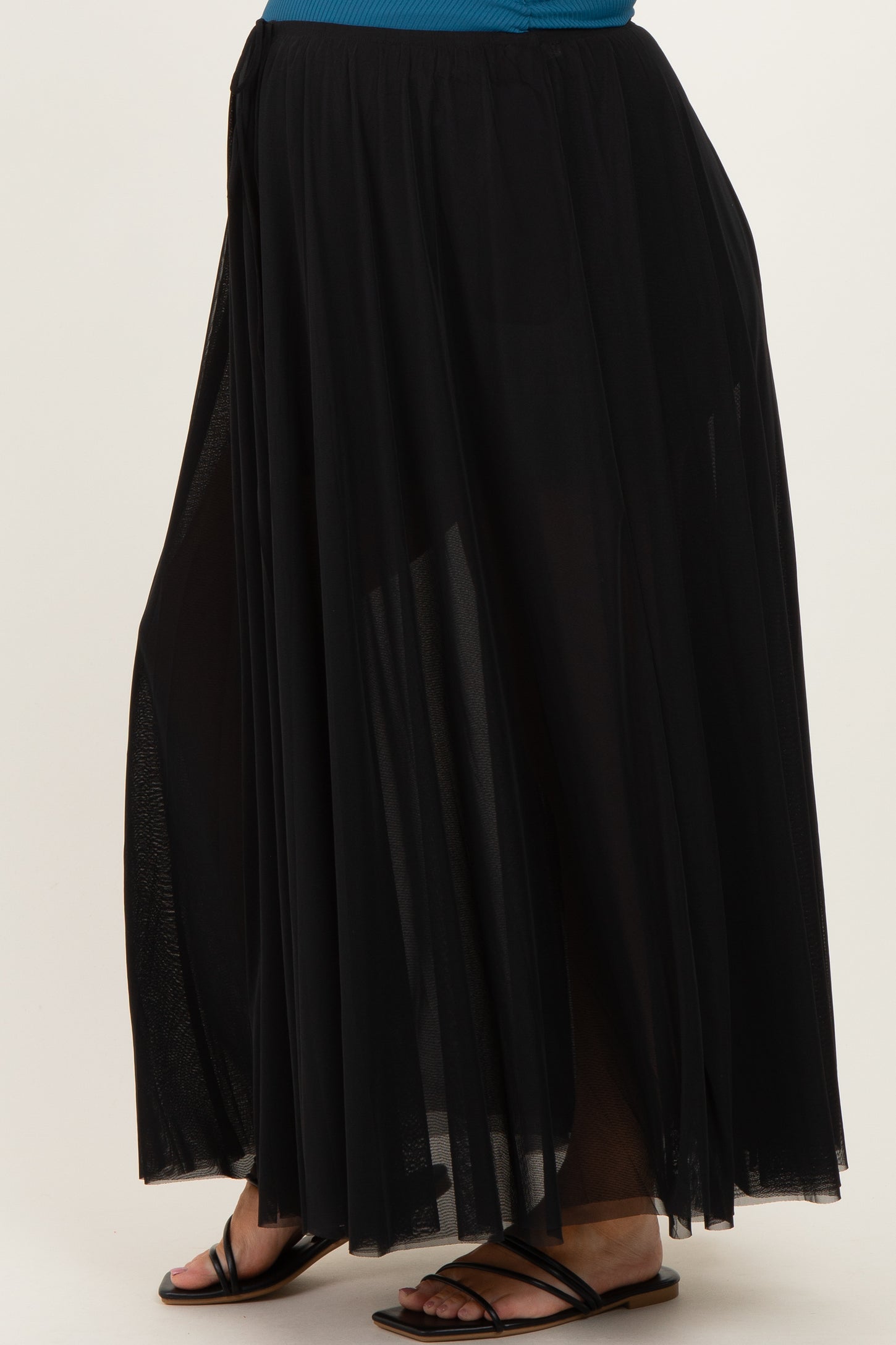 maternity wear black maxi skirt with sheer overlay and side slits, styled with a blue top and black sandals