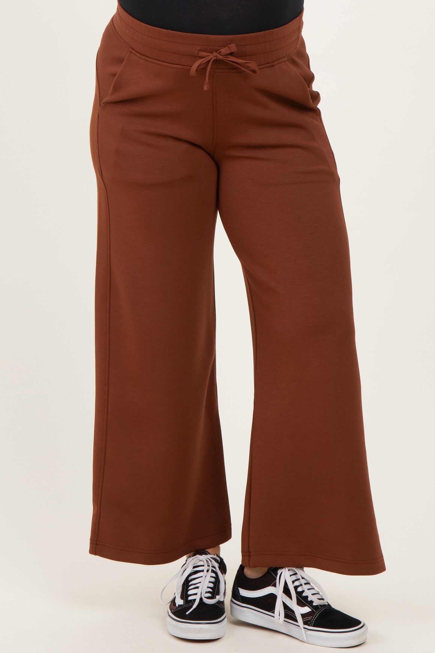 woman wearing rust-colored maternity sweatpants with a relaxed fit and drawstring waist