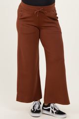 woman wearing rust-colored maternity sweatpants with a relaxed fit and drawstring waist