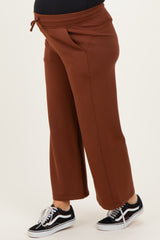 maternity wear brown wide leg pants with pockets and drawstring, worn by a model showing a baby bump