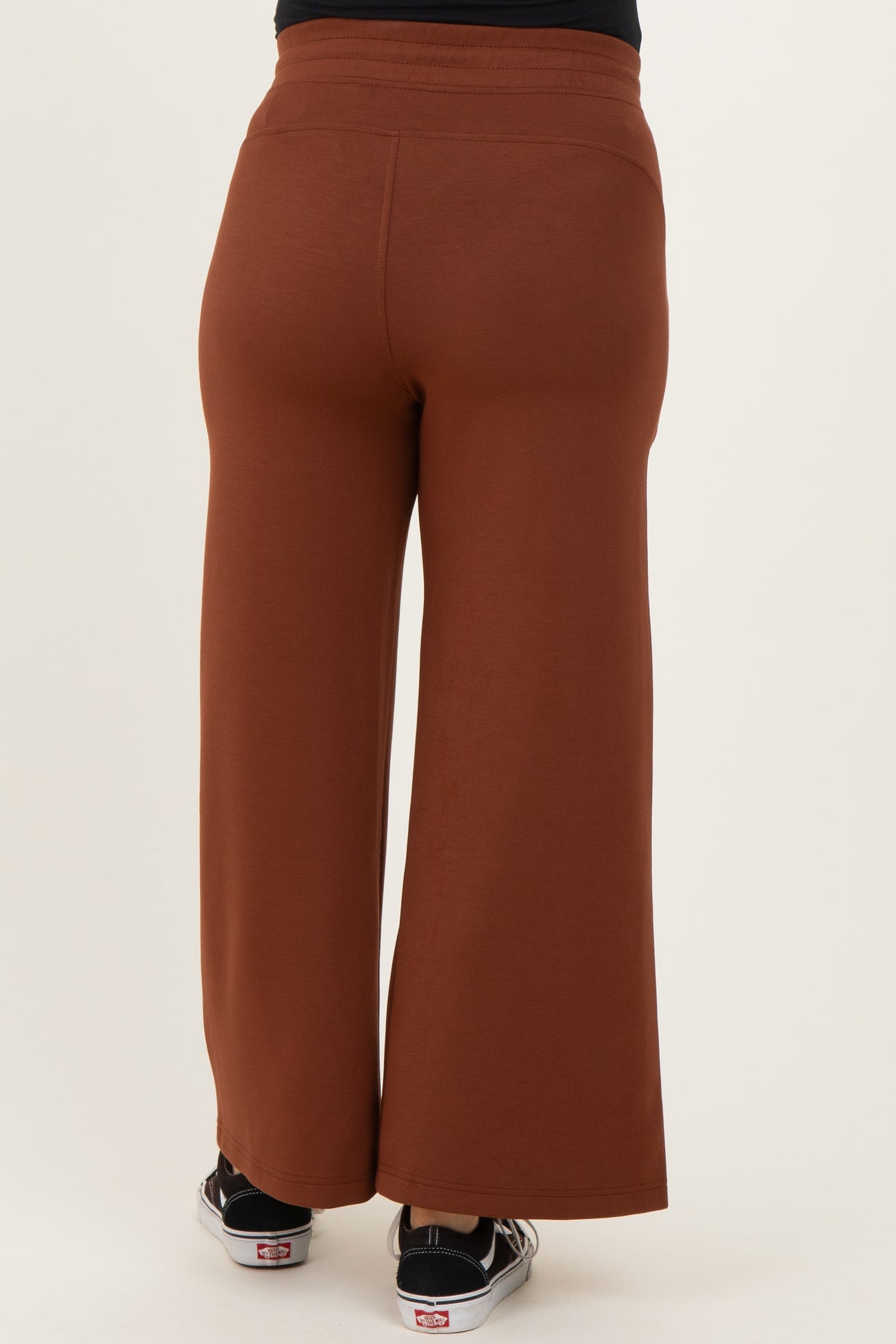 maternity wear brown wide leg pants shown from the back, model wearing casual sneakers