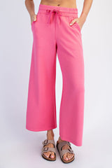 woman wearing pink wide-leg sweatpants with an elastic waistband and pockets