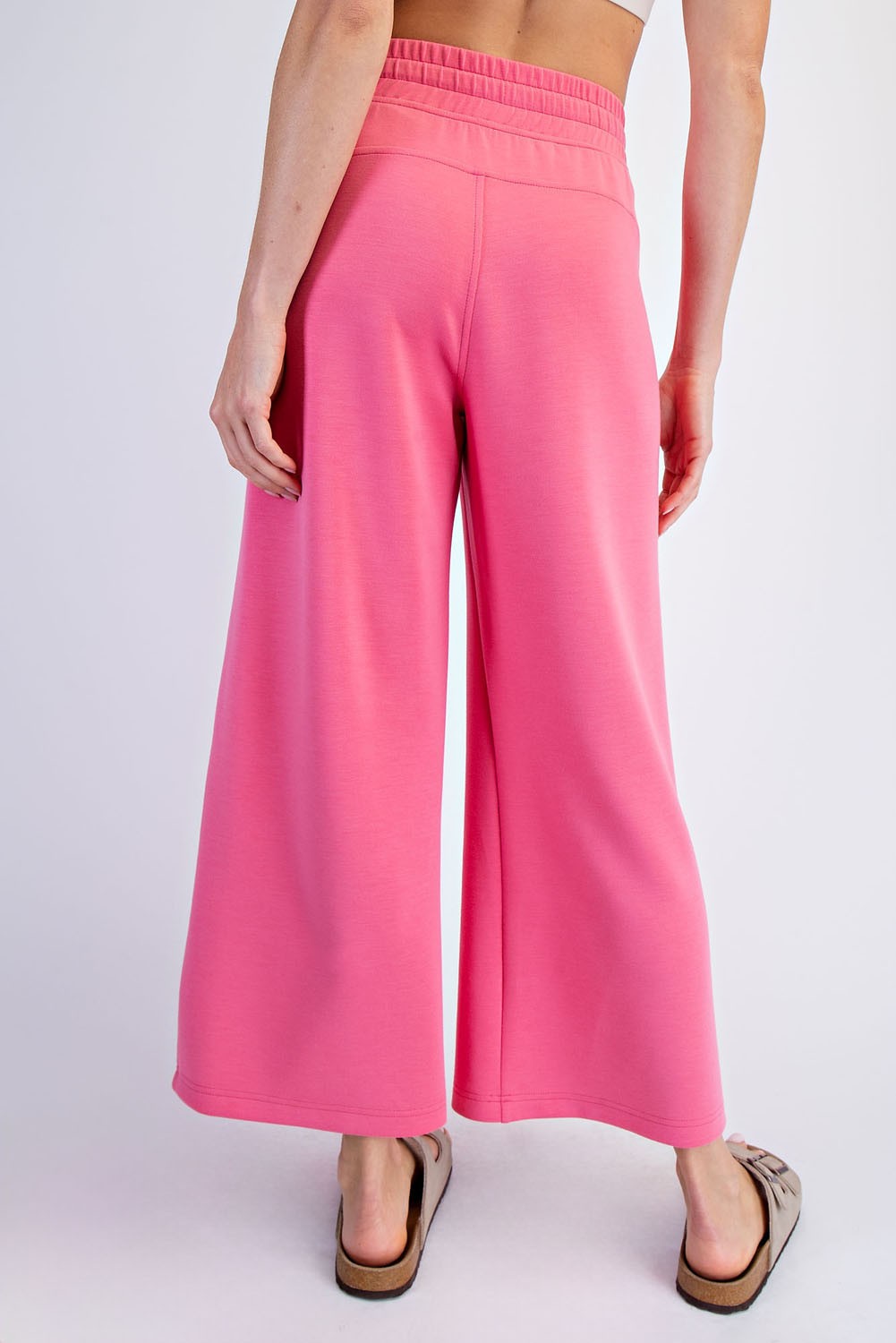 woman wearing pink wide-leg casual pants, view from the back