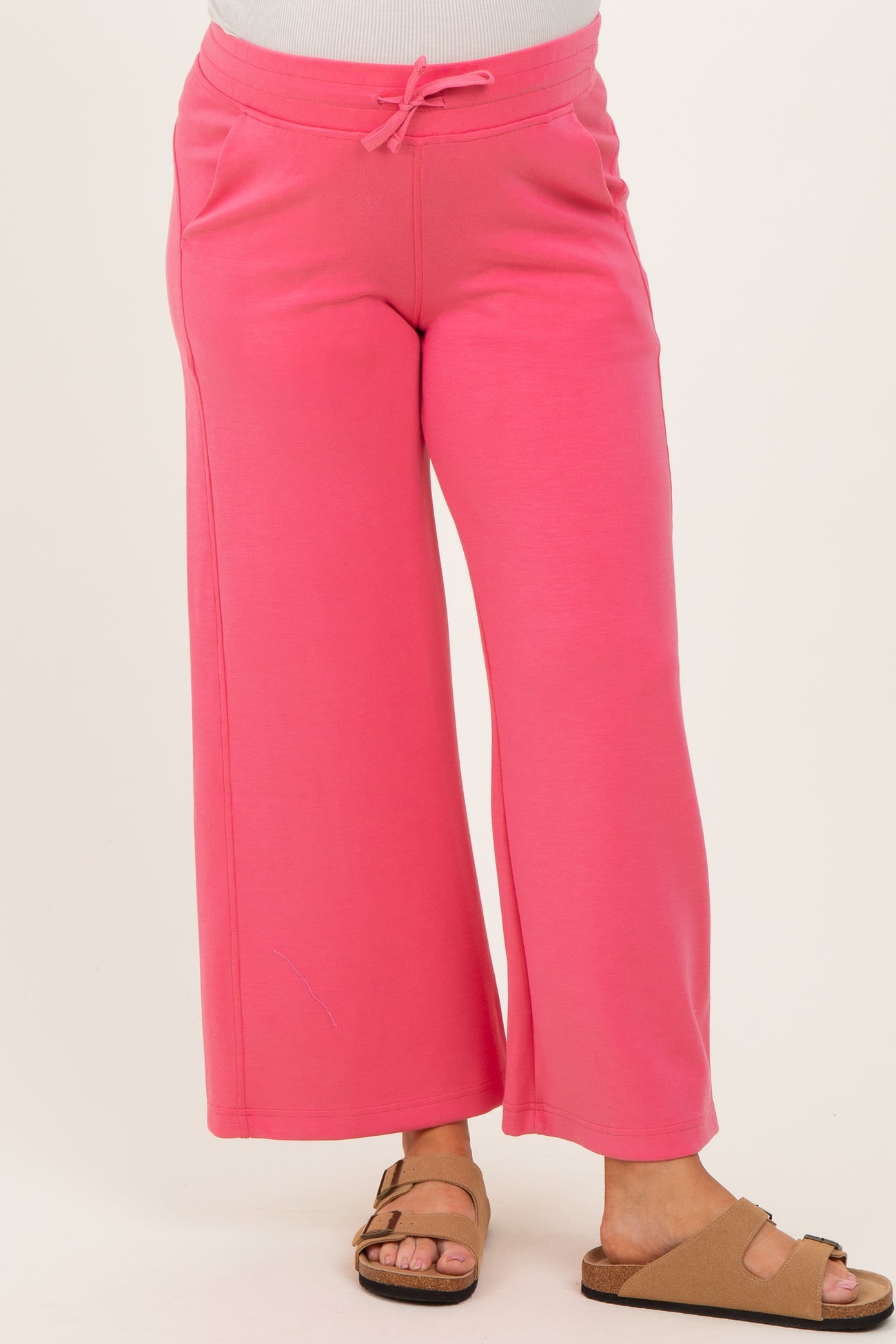 woman wearing a pair of pink maternity wide-leg sweatpants with an elastic waistband and pockets
