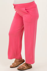 woman wearing pink maternity pants with a relaxed fit and side pockets, showing her baby bump
