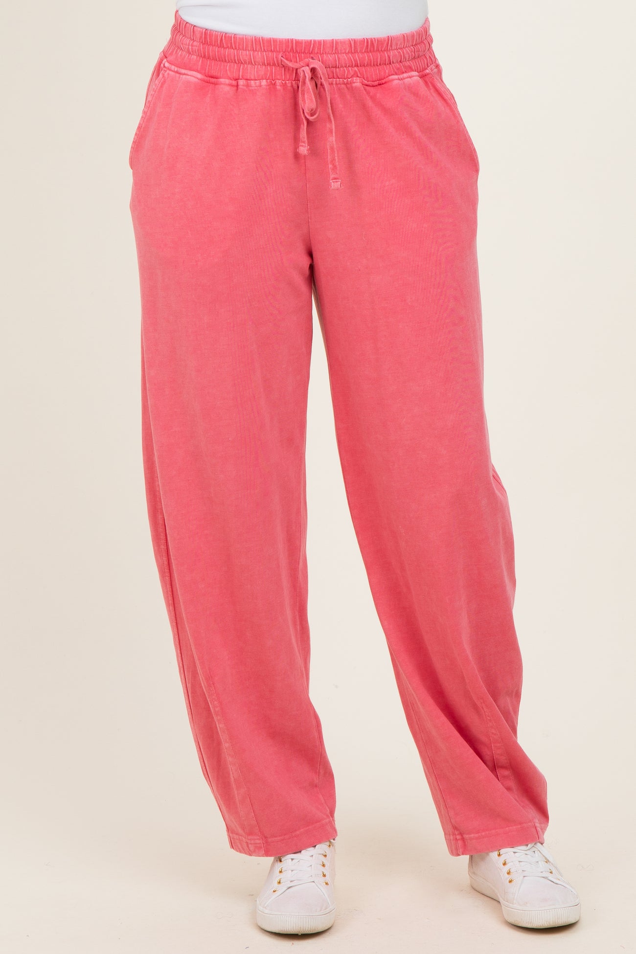 woman wearing pink loose-fit sweatpants with an elastic waistband and side pockets