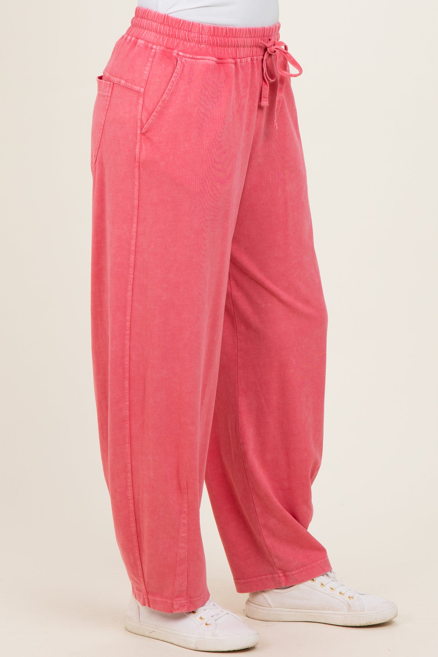 pink relaxed fit pants with a drawstring waist and side pockets, paired with white sneakers