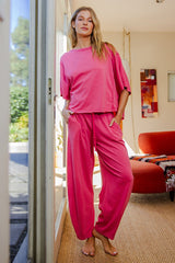 woman wearing a pink oversized t-shirt and matching loose-fitting pants