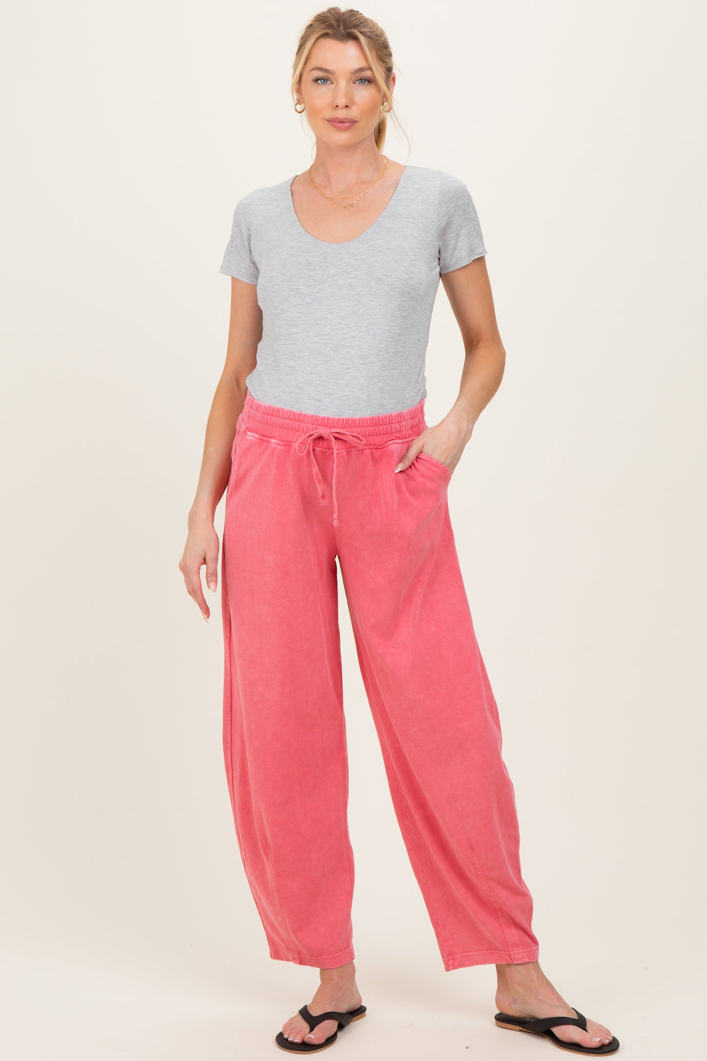 woman wearing gray short sleeve top and pink maternity pants with pockets, styled for comfort