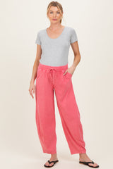 woman wearing gray short sleeve top and pink maternity pants with pockets, styled for comfort