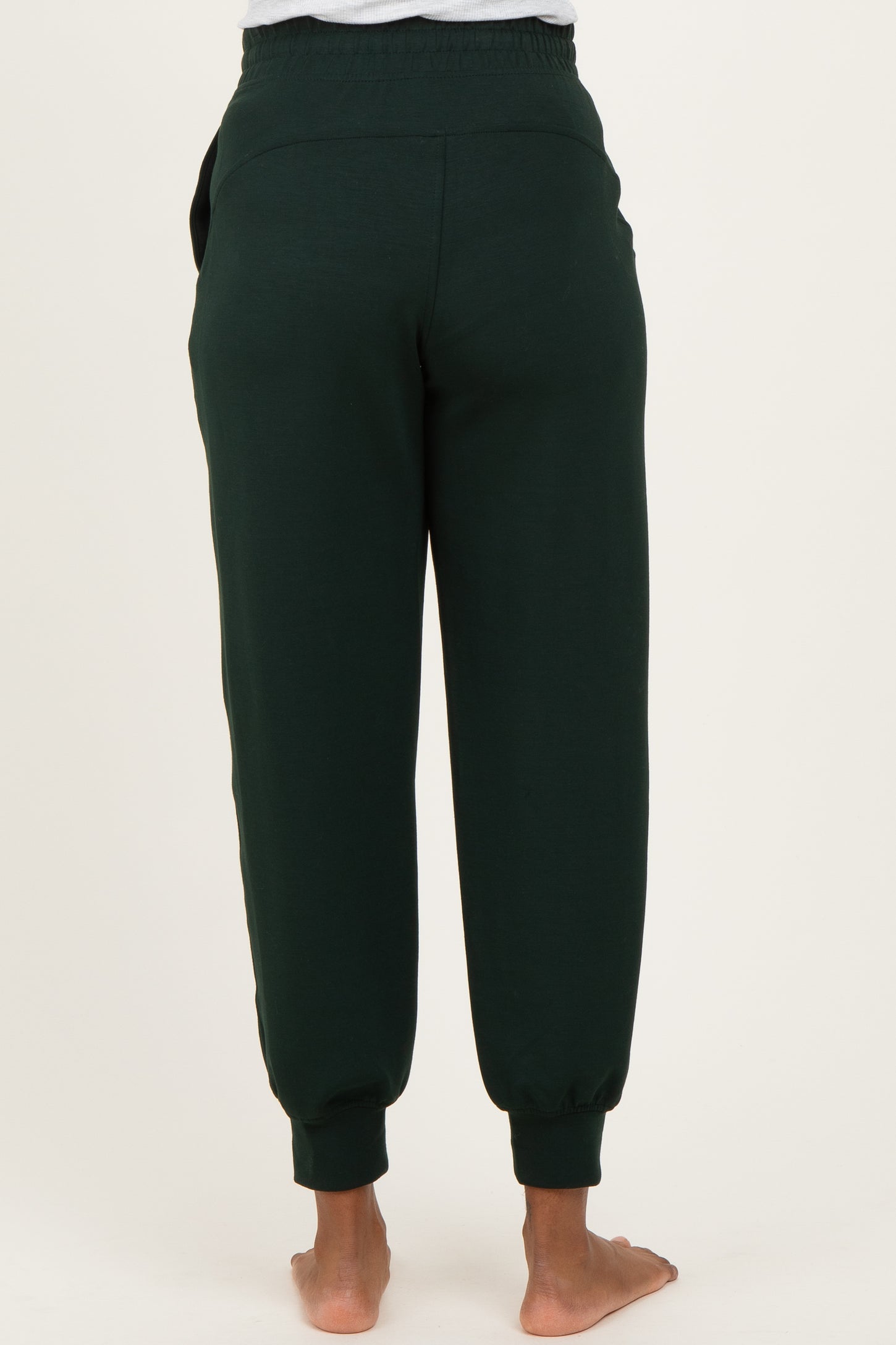 woman wearing dark green maternity jogger pants viewed from the back