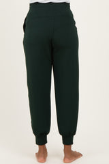 woman wearing dark green maternity jogger pants viewed from the back