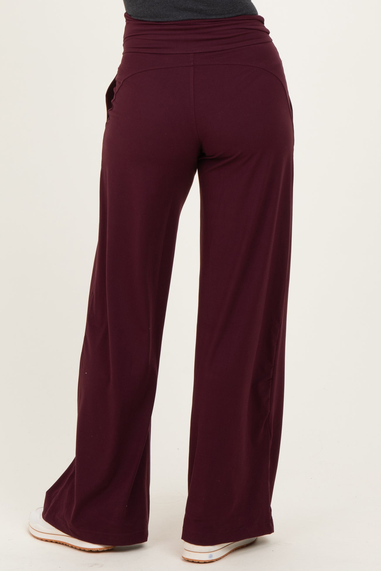 woman wearing burgundy wide-leg pants, viewed from the back, showing a relaxed fit and elastic waistband