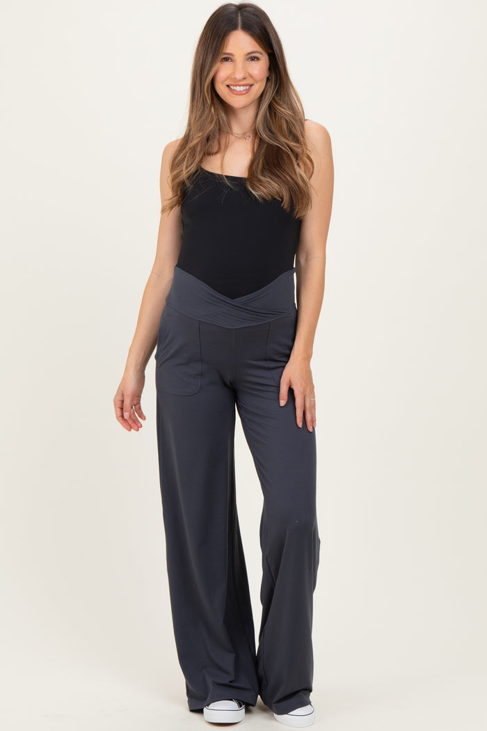woman wearing a black maternity bodysuit and gray wide-leg maternity pants with a flattering waistband