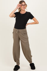 woman wearing a black short sleeve maternity top and khaki ribbed maternity joggers with pockets and drawstring