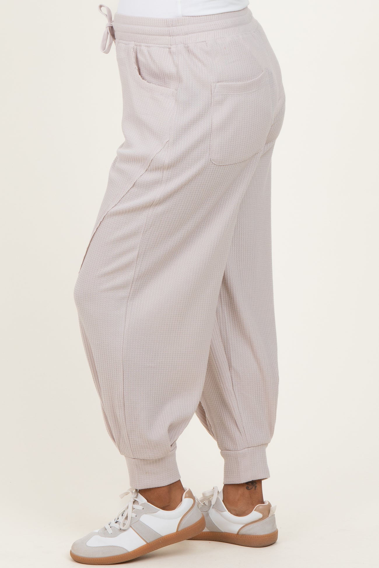 woman wearing light pink maternity jogger pants with a relaxed fit and side pockets