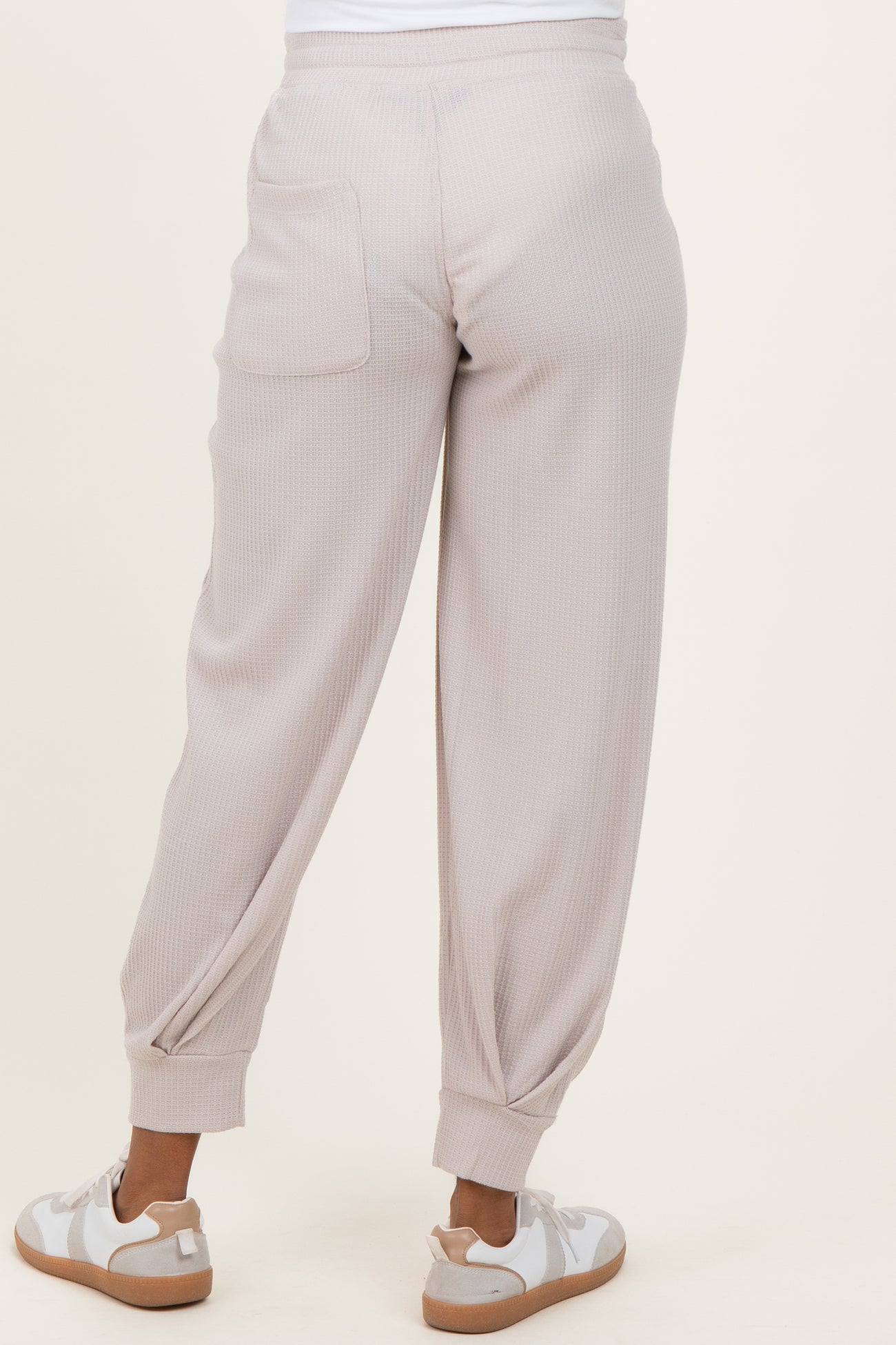 maternity wear light taupe ribbed joggers with elastic cuffs and back pocket, model shown from back