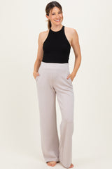 woman wearing a black halter top and light gray maternity wide-leg pants with pockets