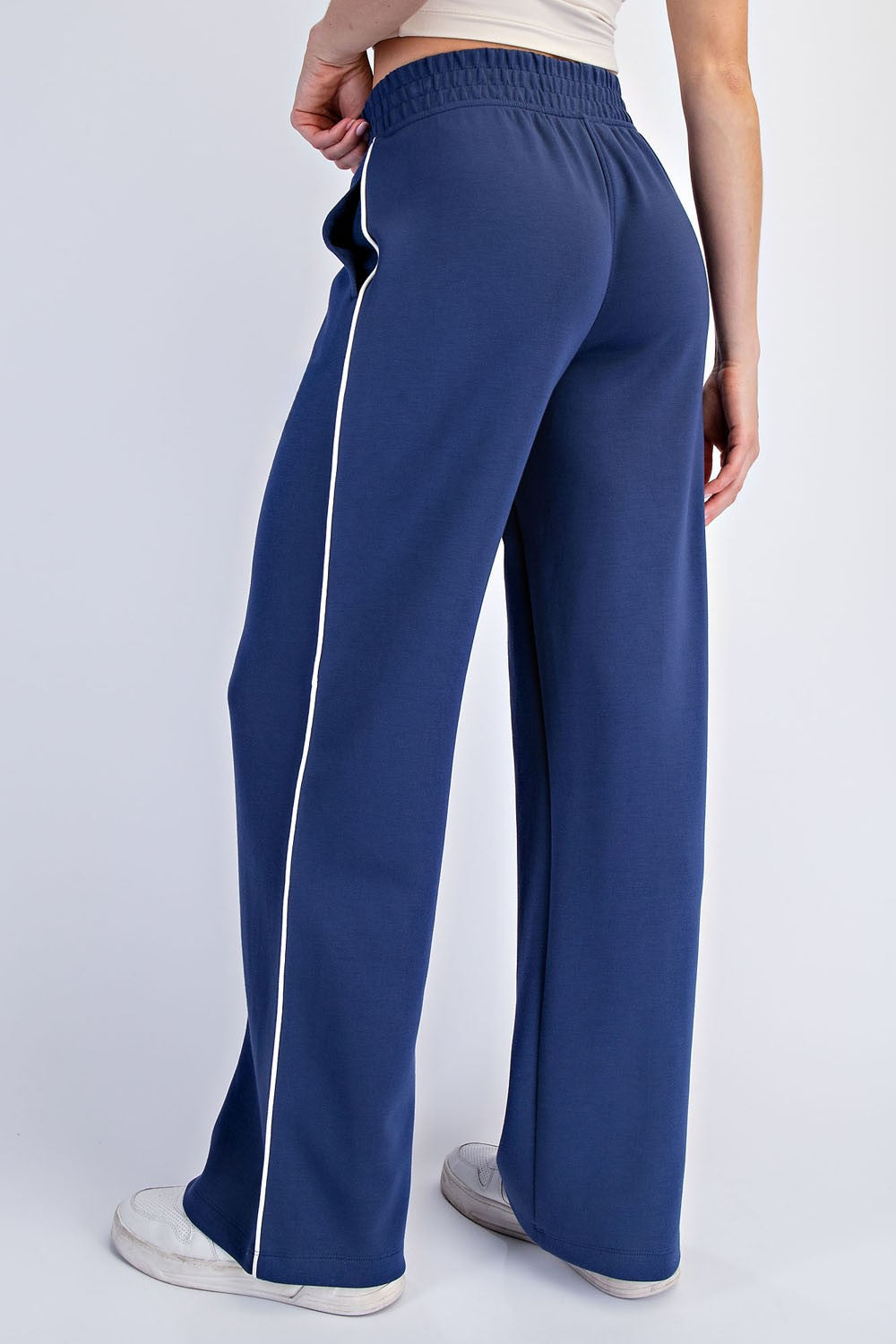 woman wearing navy blue wide-leg sweatpants with white side stripes