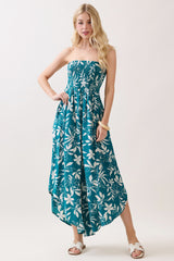 woman wearing a strapless teal floral maxi dress with a high-low hem and a smocked bodice