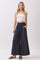 woman wearing a white strapless top and navy wide-leg pants with pockets