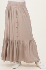 maternity wear in a taupe maxi skirt with a tiered design and button detailing, paired with white sneakers