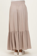 woman wearing a flowy beige maternity maxi skirt with a tiered ruffle hem and elastic waistband