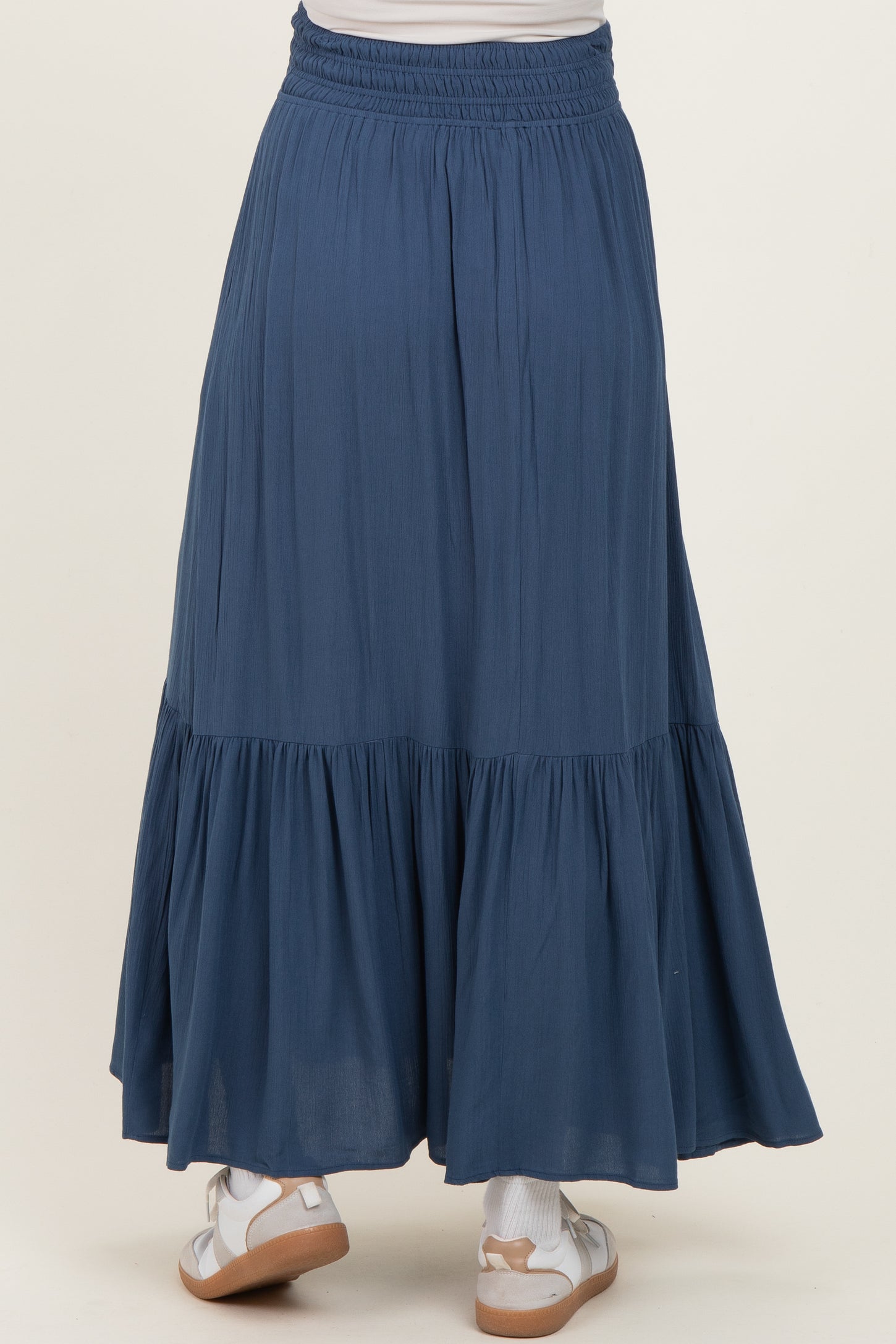 maternity wear flowy blue maxi skirt with a tiered hem and elastic waistband, shown from the back
